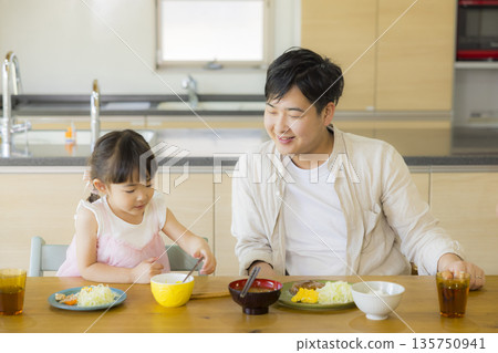 一家人其樂融融地圍坐在餐桌旁 135750941