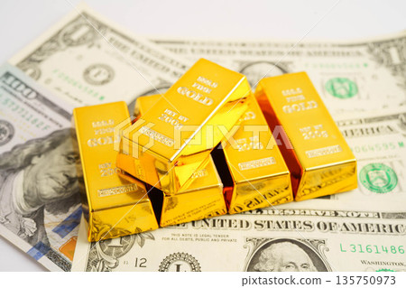 Gold bars on US dollar banknote money, finance trading investment business currency concept. Gold bars on US dollar banknote money, finance trading investment business currency concept. 135750973