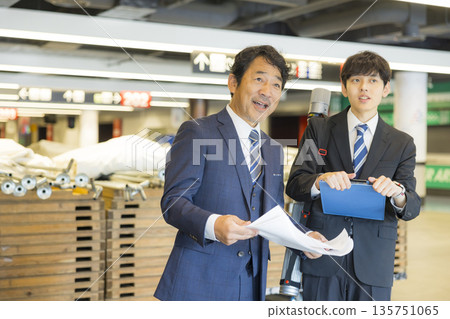 A middle-aged man in a suit managing the event 135751065