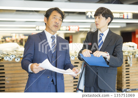 A middle-aged man in a suit managing the event 135751069