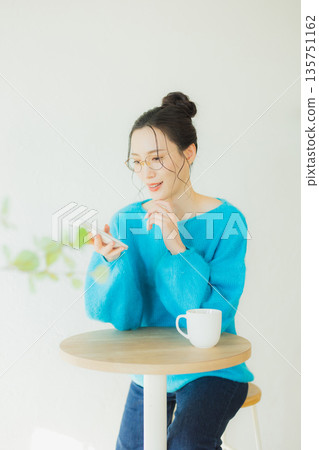 A woman watching a smartphone A woman watching a smartphone 135751162