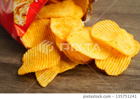 Potato chips in open bag, delicious BBQ seasoning spicy for crips, thin slice deep fried snack fast food. Potato chips in open bag, delicious BBQ seasoning spicy for crips, thin slice deep fried snack fast food. 135751241