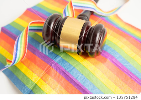 Gavel for judge lawyer on rainbow flag, symbol of LGBT pride month. Gavel for judge lawyer on rainbow flag, symbol of LGBT pride month. 135751284