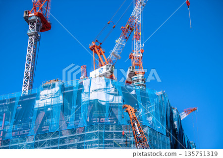 A new view of Tokyo's urban landscape in Japan. TOKYO TORCH: Huge steel structures and cranes in Otemachi. Towards a brighter era. 135751319