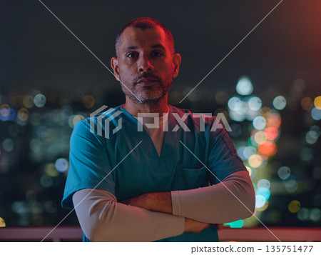 Male medic working night shift against city lights Male medic working night shift against city lights 135751477