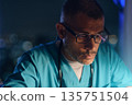Male medic working hard during night shift 135751504