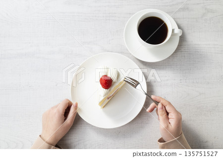 女人的手在吃草莓蛋糕 女人的手在吃草莓蛋糕 135751527
