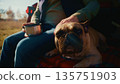 A Serene Moment: A Person Enjoys a Warm Beverage While Relaxing with Their Adorable French Bulldog Amidst Nature's Beauty on a Peaceful Day 135751903