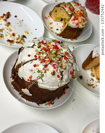 Traditional Easter cakes topped with white icing, colorful candied fruit are arranged on plates, bright accents contrast with golden baked texture Traditional Easter cakes topped with white icing, colorful candied fruit are arranged on plates, bright accents contrast with golden baked texture 135752442