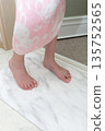 A girl wiping her feet on a diatomaceous earth bath mat 135752565
