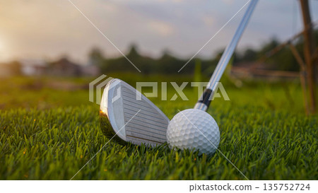 Golf clubs and balls on a green lawn in a beautiful golf course with morning sunshine. 135752724