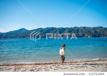 Young woman walking along the seaside in winter 135752804