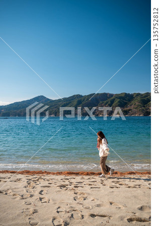 Young woman walking along the seaside in winter 135752812