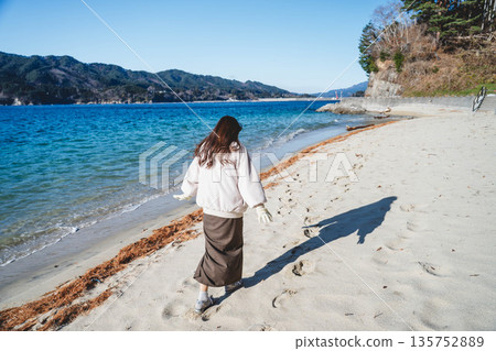 Woman taking pictures at the seaside 135752889