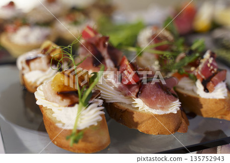 Delicious gourmet appetizers arranged beautifully on a serving platter 135752943