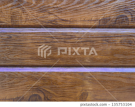 Brown wooden wall made of planks with natural grain pattern. Texture of wood panel for rustic background. Close up of hardwood material. 135753104