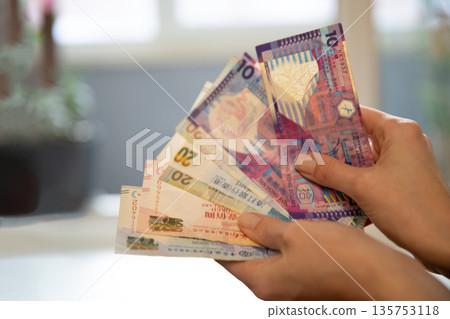Woman holding Hong Kong dollar banknotes, close up. Cash money exchange and finance concept for banking account and payment. Woman holding Hong Kong dollar banknotes, close up. Cash money exchange and finance concept for banking account and payment. 135753118