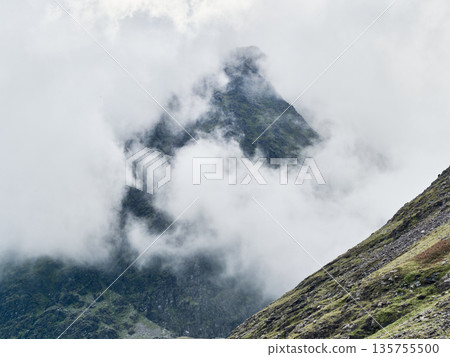The peak of Carrauntoohil mountain is dramatically veiled by rolling clouds in Ireland. The peak of Carrauntoohil mountain is dramatically veiled by rolling clouds in Ireland. 135755500