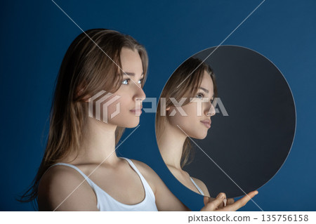 Woman seeing her reflection in round mirror Woman seeing her reflection in round mirror 135756158