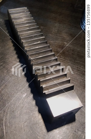 Toothed pinion on an open toothed shaft. Steel part on the even. Mechanical engineering. Finished products. 135756899