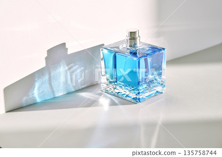 Blue perfume bottle casting light refraction shadow Blue perfume bottle casting light refraction shadow 135758744