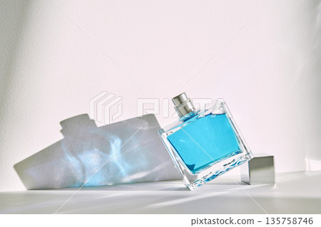 Perfume bottle with blue liquid creating shadows Perfume bottle with blue liquid creating shadows 135758746