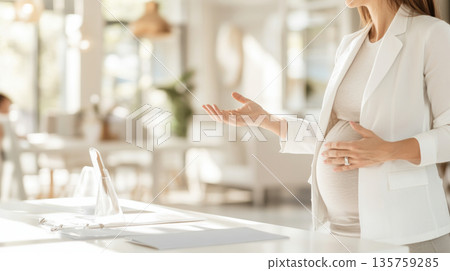 Pregnant woman in bright modern office setting with colleagues, copy space background 135759285