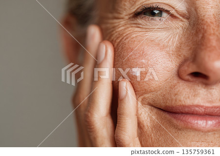 cropped portrait of a middle-aged woman caring for her face with cream cropped portrait of a middle-aged woman caring for her face with cream 135759361