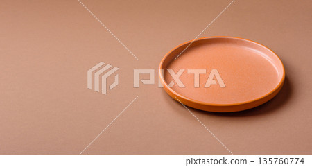 An empty round ceramic plate on a table, kitchenware. An empty plate An empty round ceramic plate on a table, kitchenware. An empty plate 135760774