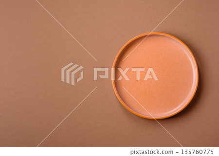 An empty round ceramic plate on a table, kitchenware. An empty plate An empty round ceramic plate on a table, kitchenware. An empty plate 135760775