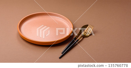 An empty round ceramic plate on a table, kitchenware. An empty plate 135760778