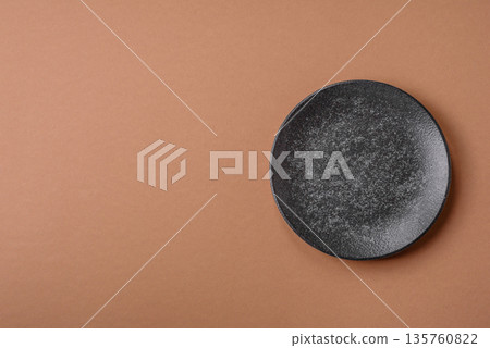 An empty round ceramic plate on a table, kitchenware. An empty plate An empty round ceramic plate on a table, kitchenware. An empty plate 135760822