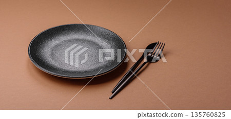 An empty round ceramic plate on a table, kitchenware. An empty plate An empty round ceramic plate on a table, kitchenware. An empty plate 135760825