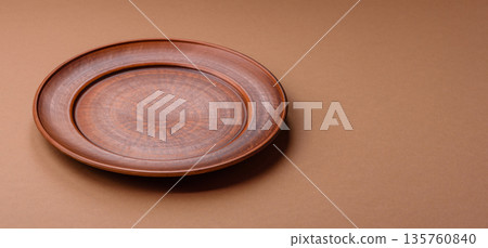 An empty round ceramic plate on a table, kitchenware. An empty plate An empty round ceramic plate on a table, kitchenware. An empty plate 135760840