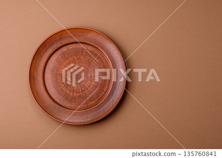 An empty round ceramic plate on a table, kitchenware. An empty plate An empty round ceramic plate on a table, kitchenware. An empty plate 135760841