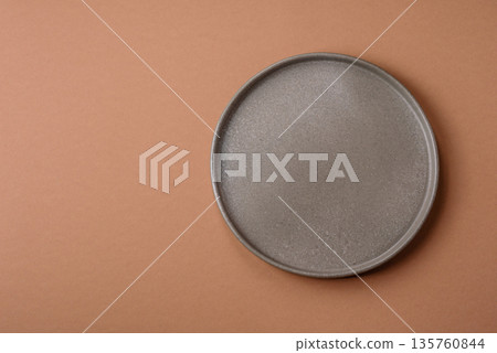 An empty round ceramic plate on a table, kitchenware. An empty plate An empty round ceramic plate on a table, kitchenware. An empty plate 135760844