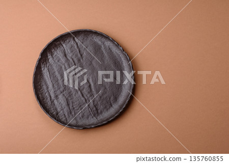 An empty round ceramic plate on a table, kitchenware. An empty plate An empty round ceramic plate on a table, kitchenware. An empty plate 135760855
