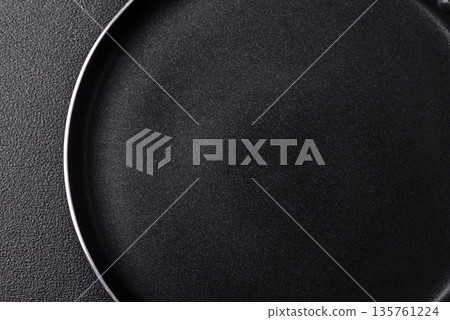 An empty black metal frying pan, kitchen utensils for cooking. An empty frying pan An empty black metal frying pan, kitchen utensils for cooking. An empty frying pan 135761224