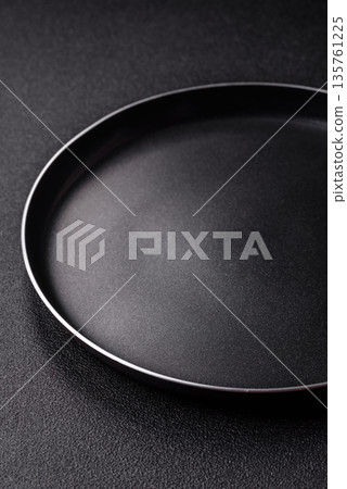 An empty black metal frying pan, kitchen utensils for cooking. An empty frying pan An empty black metal frying pan, kitchen utensils for cooking. An empty frying pan 135761225
