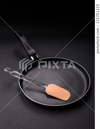 An empty black metal frying pan, kitchen utensils for cooking. An empty frying pan An empty black metal frying pan, kitchen utensils for cooking. An empty frying pan 135761229