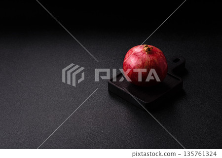 A juicy, ripe, whole red pomegranate as a source of beneficial nutrients. A whole red pomegranate A juicy, ripe, whole red pomegranate as a source of beneficial nutrients. A whole red pomegranate 135761324