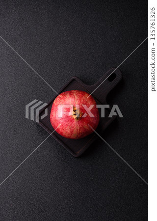 A juicy, ripe, whole red pomegranate as a source of beneficial nutrients. A whole red pomegranate A juicy, ripe, whole red pomegranate as a source of beneficial nutrients. A whole red pomegranate 135761326