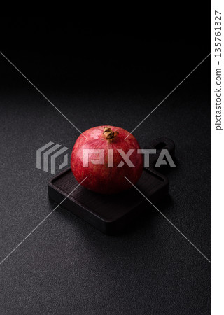 A juicy, ripe, whole red pomegranate as a source of beneficial nutrients. A whole red pomegranate A juicy, ripe, whole red pomegranate as a source of beneficial nutrients. A whole red pomegranate 135761327
