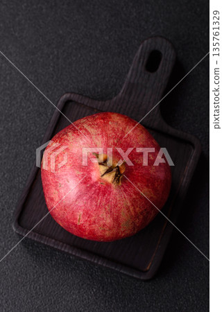 A juicy, ripe, whole red pomegranate as a source of beneficial nutrients. A whole red pomegranate A juicy, ripe, whole red pomegranate as a source of beneficial nutrients. A whole red pomegranate 135761329