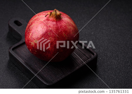 A juicy, ripe, whole red pomegranate as a source of beneficial nutrients. A whole red pomegranate A juicy, ripe, whole red pomegranate as a source of beneficial nutrients. A whole red pomegranate 135761331