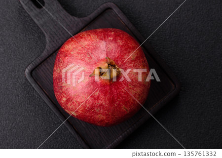 A juicy, ripe, whole red pomegranate as a source of beneficial nutrients. A whole red pomegranate A juicy, ripe, whole red pomegranate as a source of beneficial nutrients. A whole red pomegranate 135761332