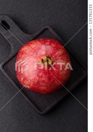 A juicy, ripe, whole red pomegranate as a source of beneficial nutrients. A whole red pomegranate A juicy, ripe, whole red pomegranate as a source of beneficial nutrients. A whole red pomegranate 135761333