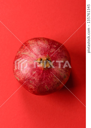 A juicy, ripe, whole red pomegranate as a source of beneficial nutrients. A whole red pomegranate A juicy, ripe, whole red pomegranate as a source of beneficial nutrients. A whole red pomegranate 135761345