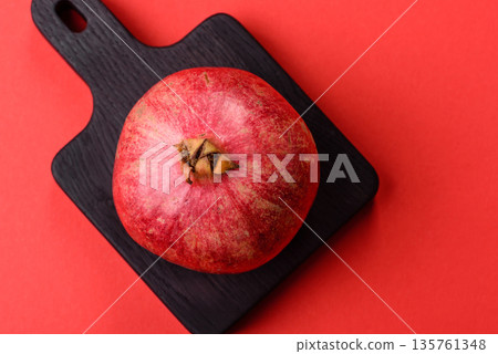 A juicy, ripe, whole red pomegranate as a source of beneficial nutrients. A whole red pomegranate A juicy, ripe, whole red pomegranate as a source of beneficial nutrients. A whole red pomegranate 135761348