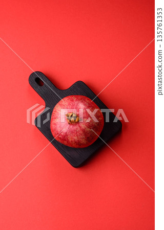 A juicy, ripe, whole red pomegranate as a source of beneficial nutrients. A whole red pomegranate A juicy, ripe, whole red pomegranate as a source of beneficial nutrients. A whole red pomegranate 135761353
